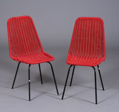 une paire de chaises en osier rouge avec des pieds en métal noir sur fond gris