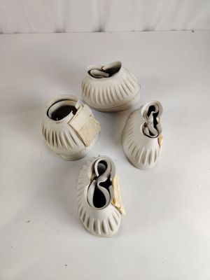 quatre vases en céramique blanche, portant des chiffres, posés sur une surface blanche