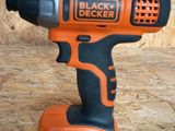 une perceuse sans fil Black & Decker sur une surface en bois