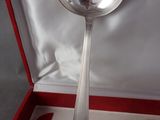 a silver spoon in a red box with a silver spoon in it