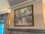 un tableau accroché au mur au-dessus de la cheminée dans un salon
