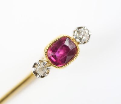 a close up of a pink stone and diamond ring on a stick