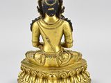 a gold statue of a person sitting in a lotus position