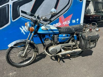 une moto bleue garée devant un mur recouvert de graffitis
