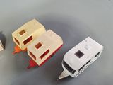 several toy cars and a boat are on a table next to other toys