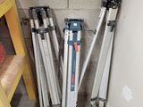 several tripods are lined up against a wall in the corner of a room
