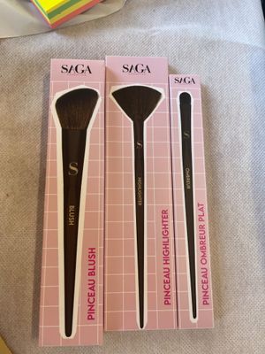 trois pinceaux de maquillage posés les uns sur les autres sur une table