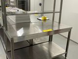 une cuisine avec des plans de travail en inox et un seau bleu