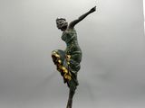 statue d'une femme en robe verte posée sur un socle en bois