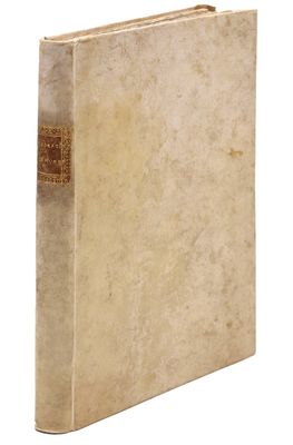 un vieux livre posé sur une table blanche à côté d'un mur blanc