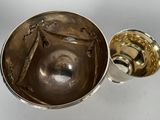a silver bowl and a silver cup on a table