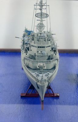 a model of a battleship on display on a blue surface