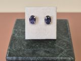 un gros plan sur une paire de boucles d'oreilles en saphir bleu posées sur un bloc de marbre