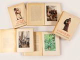 plusieurs livres ouverts, sur lesquels figurent des photos de personnes, posés sur une table