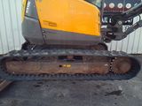 an image of a small excavator parked in front of a building