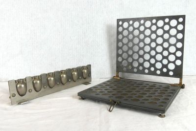 two pieces of metal with holes on them on a white surface