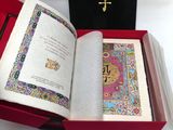 un livre ouvert dans une boîte rouge posée sur une table blanche