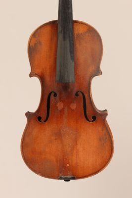 un gros plan d'un violon posé sur un pupitre, sur fond blanc