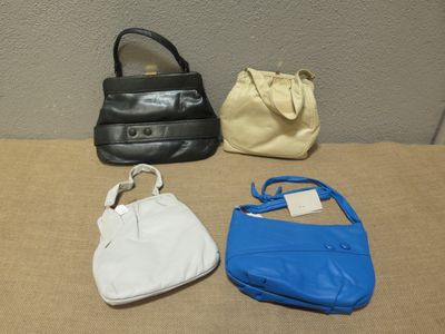 Plusieurs sacs à main sont alignés sur une table dans une pièce