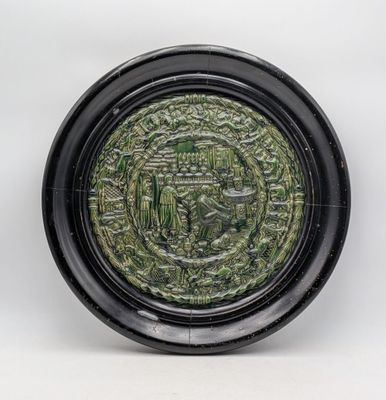 an image of a green and black plate on a white surface