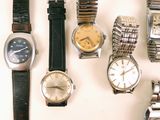 many different types of watches displayed on a white surface