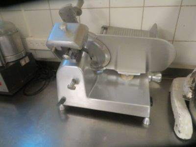 an image of a commercial meat slicer on a kitchen counter