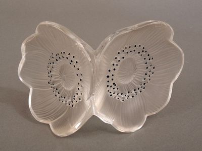 a white flower shaped object with black dots on it