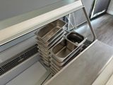 several trays of food are stacked on top of each other in a kitchen
