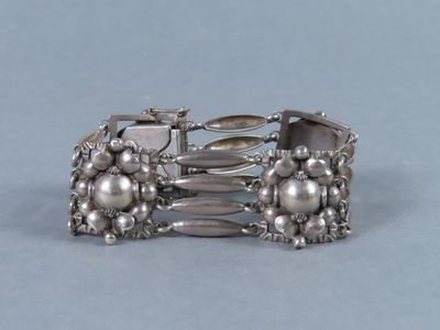 un gros plan d'un bracelet en argent sur un fond bleu