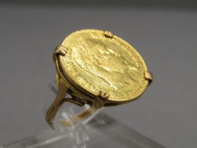 une image représentant une bague en or sur laquelle repose une pièce d'or