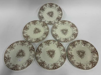 six assiettes marron et blanches ornées de motifs floraux sur fond blanc