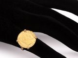 an image of a ring with a gold coin on it ' s finger