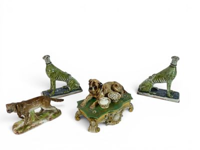 three figurines of animals and a dog are sitting on a table