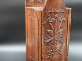 a small wooden cabinet with a carved design on the front