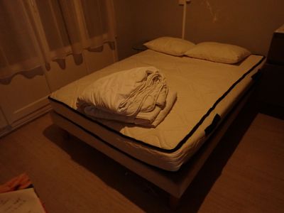 a bed that has a sheet on it in a room