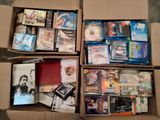 un grand nombre de dvd dans une boîte posée sur le sol