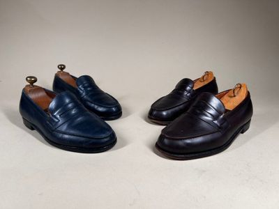 two pairs of men ' s shoes are lined up on a white surface