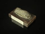 a small stone with a sign on it on a black surface