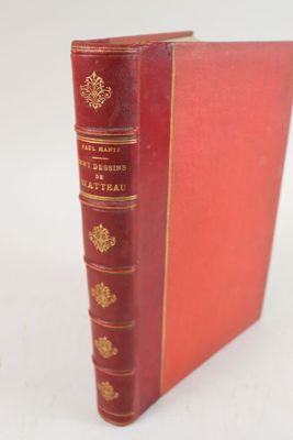 un vieux livre rouge posé sur une table blanche