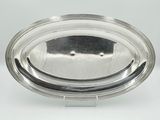 an oval silver plate on a stand with a clear glass lid