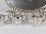 a silver tray with six cups and a tray with a silver tray