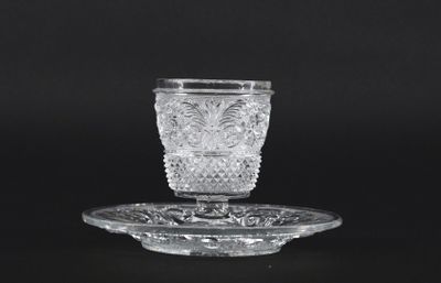 crystal cup and saucer on a plate on a black background