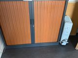 une armoire avec une porte et un micro-ondes posé sur le plan de travail