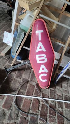 a sign that says tabac on it on a brick floor