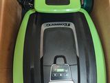 a green and black vacuum in a box with a stop sign on it