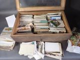 a wooden box filled with lots of papers and cards