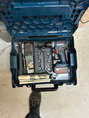 une boîte à outils bleue avec des outils sur le sol