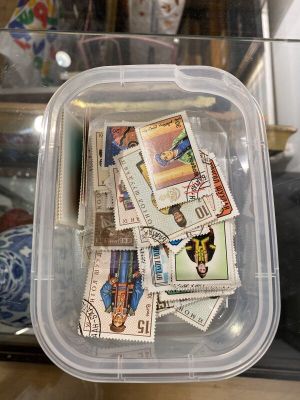 un récipient en plastique rempli de timbres posé sur une table