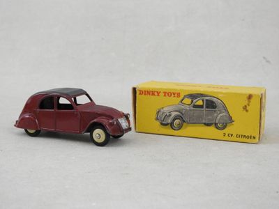 une petite voiture rouge à côté d'une boîte jaune