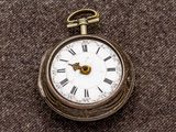 a small pocket watch with roman numerals on it